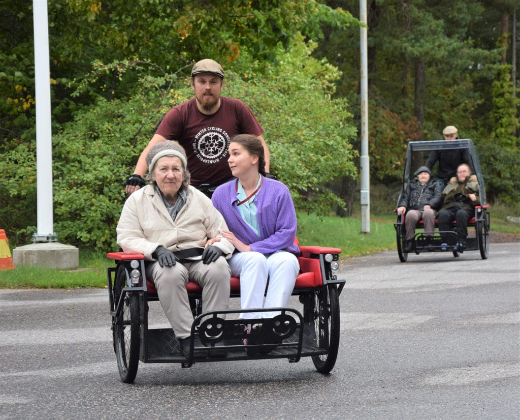 Kaksi riksaa joiden kyydissä kaksi ihmistä kummassakin.