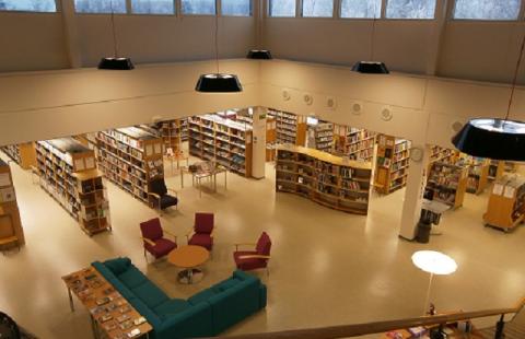 The library has a large soft toy and a decorative reading chair.