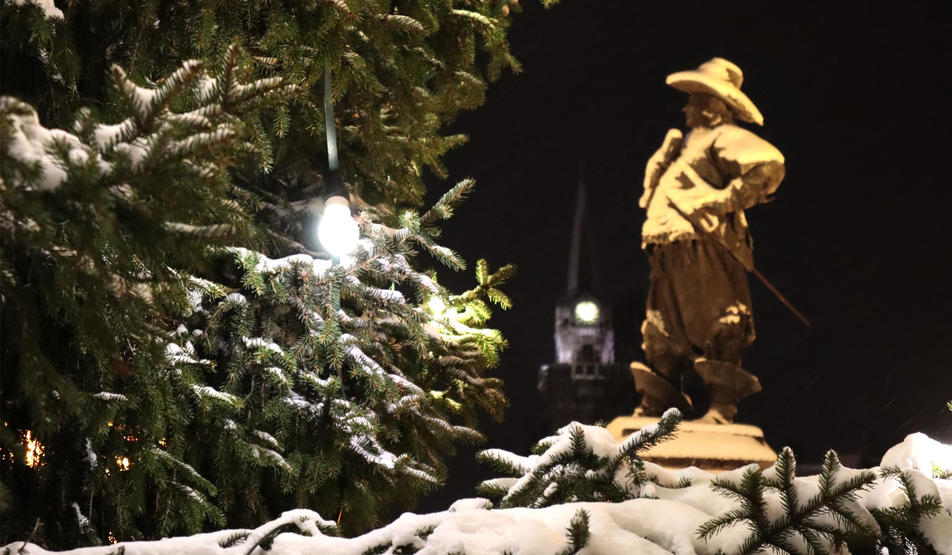 The snowy Pekka statue captured with spruce branches.