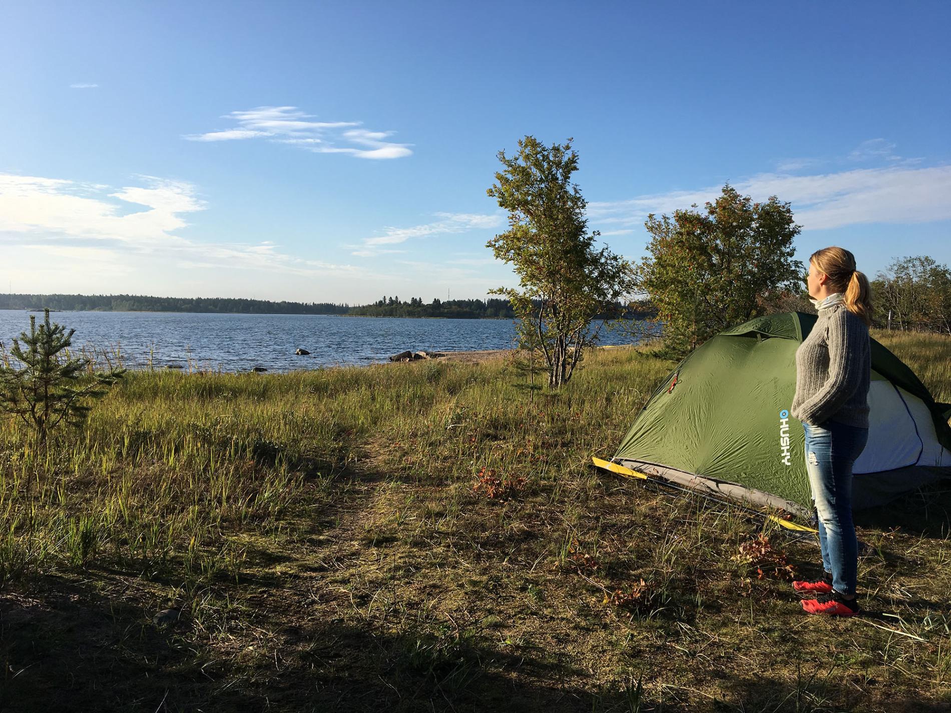 Nainen seisomassa teltan edessä saaressa.