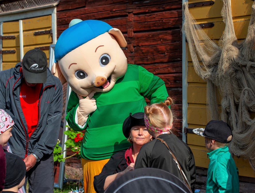 A pig character listening to the children’s stories.